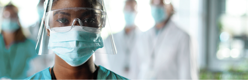 Profissional de enfermagem com máscara e face shield em ambiente hospitalar, simbolizando atuação em Unidade de Terapia Intensiva Adulto.